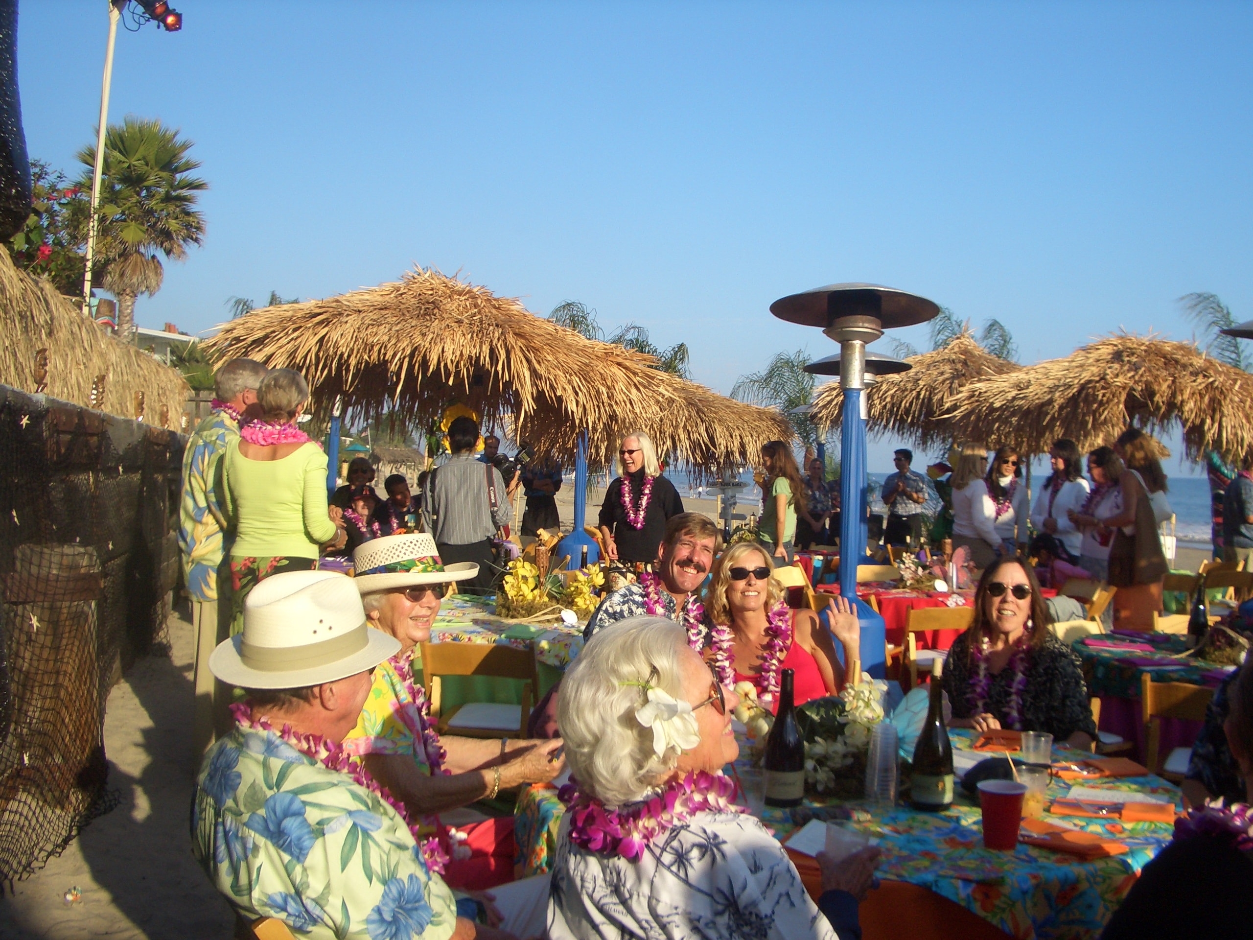 Wide shot of a professionally staged outdoor luau performance stage decorated with tropical elements by Manea Florida